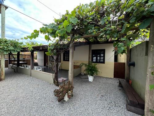 a house with a courtyard with a tree in it at Casa privativa com piscina na Praia da Ferrugem duas quadras mar REF 100 in Garopaba