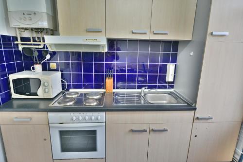 a small kitchen with a sink and a microwave at Guesthouse Sermageova in Zagreb