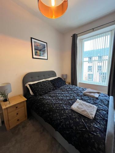 a bedroom with a bed and a window at TheFlatInJed in Jedburgh
