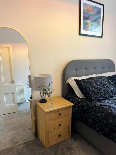a bedroom with a bed and a lamp on a night stand at TheFlatInJed in Jedburgh