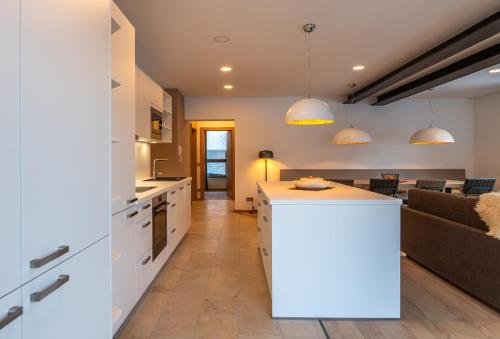 an open kitchen and living room with a couch at Nockschnucke homes - Kärnten Card im Sommer inklusive in Bad Kleinkirchheim