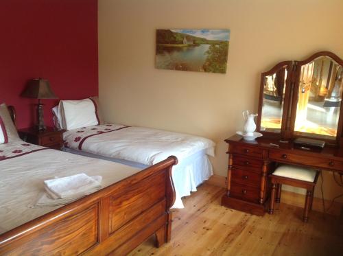 a bedroom with two beds and a dresser with a mirror at Country House B@b in New Twopothouse Village