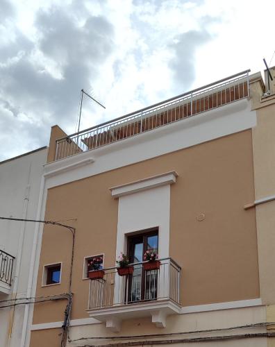 a building with a balcony with flowers on it at B&b La Campanella in Palagianello
