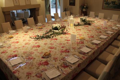 a long table with flowers on top of it at Hotel Calvi-Ristorante Mainor in Vittorio Veneto