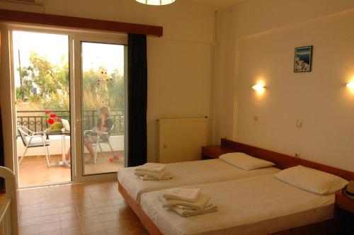 a hotel room with two beds and a balcony at Prasonisi Club in Kattavía