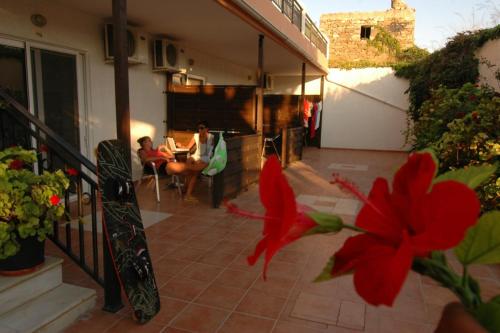 a group of people sitting on a porch of a house at Prasonisi Club in Kattavía