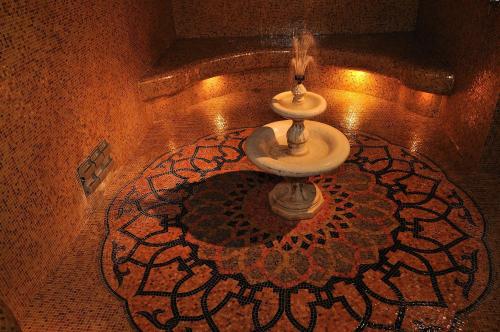 una fontana in una stanza con pavimento a mosaico di TH Cinisi - Florio Park Hotel a Cinisi