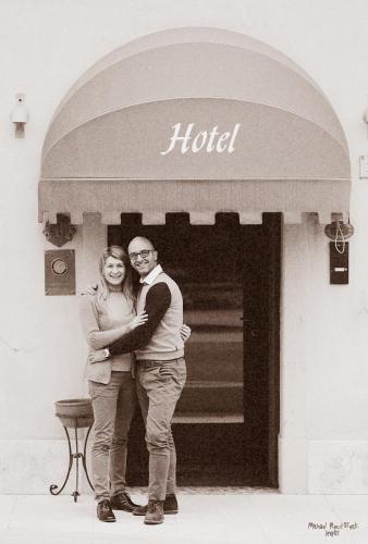 a man and woman standing in front of a hotel at Hotel Calvi-Ristorante Mainor in Vittorio Veneto