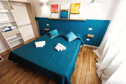 a room with a blue bed with towels on it at Boccaccio Apartment in Ravenna