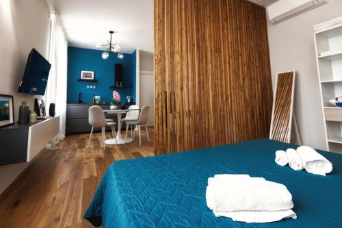 a bedroom with a blue bed with white towels on it at Boccaccio Apartment in Ravenna