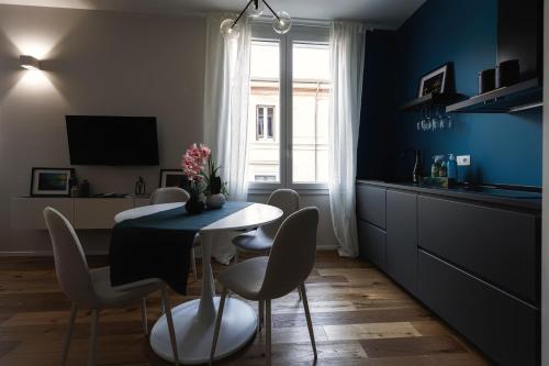 a dining room with a table and chairs and a kitchen at Boccaccio Apartment in Ravenna