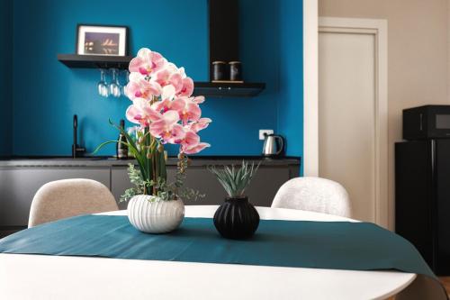 a table with two vases with pink flowers on it at Boccaccio Apartment in Ravenna