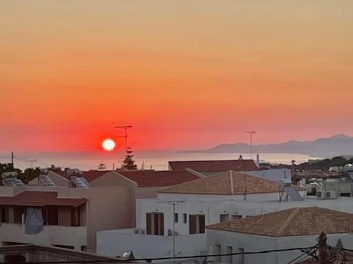 a sunset over a city with houses and the ocean at Calergi Residence - Holidays in Crete in Atsipopoulo
