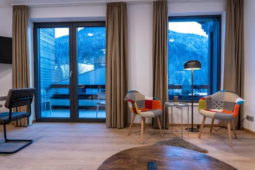 a living room with chairs and a large window at Nockschnucke homes - Kärnten Card im Sommer inklusive in Bad Kleinkirchheim