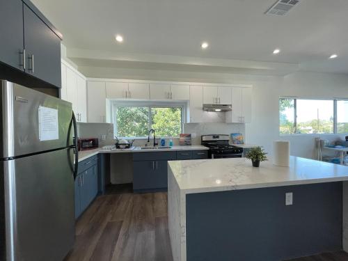 a kitchen with blue and white cabinets and a refrigerator at Blue Stay Walk to BMO Stadium and USC in Los Angeles