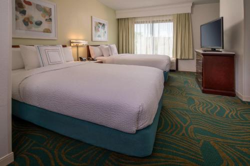 a hotel room with two beds and a flat screen tv at SpringHill Suites by Marriott Gaithersburg in Gaithersburg