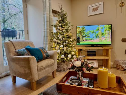 a living room with a christmas tree and a television at River Dance Cottage, Aysgarth in Aysgarth