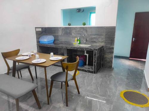 a dining room with a table and chairs and a counter at SK Sweet Homestay SP Kedah in Sungai Petani