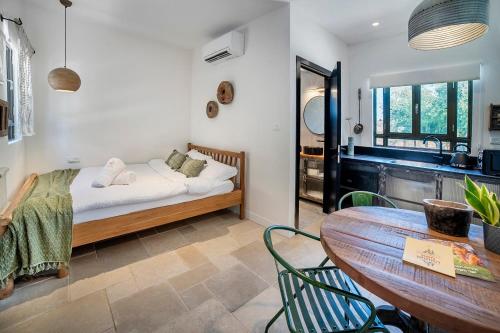 a room with a bed and a table and a kitchen at אירוח יער השלום in Jerusalem