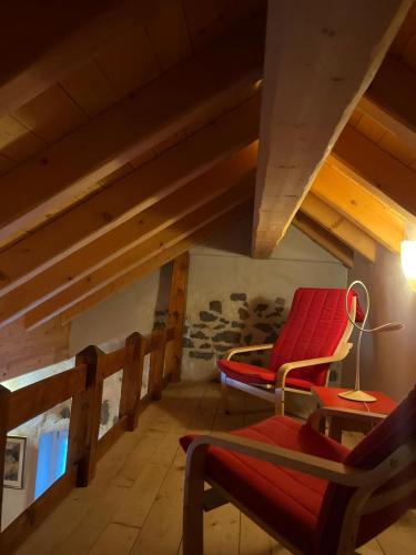 a attic room with red chairs and a lamp at Castel Madonna in San Martino di Castrozza