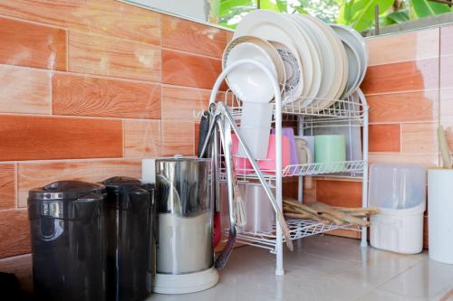 a dish rack with plates and other dishes on a counter at Puting Bakod- Vacation Home with Mountain & Lake View in Jalajala