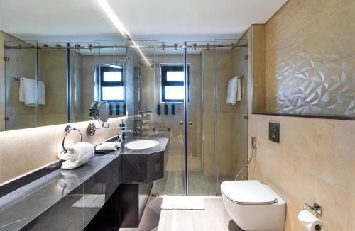 a bathroom with a toilet and a sink and a shower at Doubletree By Hilton Amman Hotel & Residences in Amman
