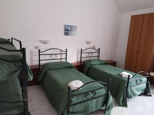 two beds in a room with green sheets at Holiday Residence in Casamassima