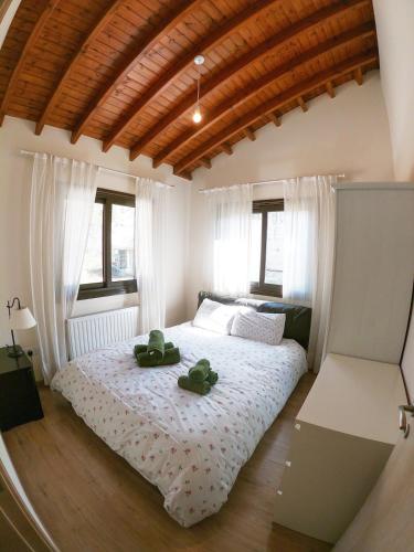 a bedroom with a bed with two green shoes on it at Orama Mountain Villa Farmakas in Nicosia