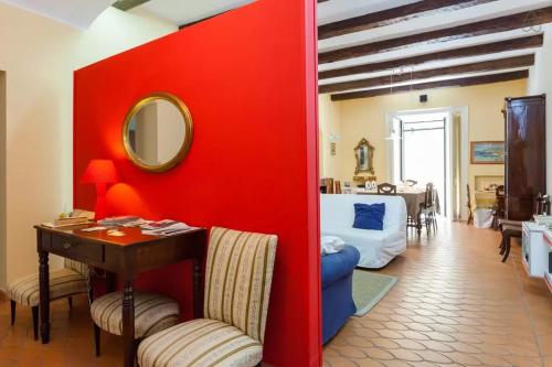 a room with a red wall with a desk and a bedroom at Bed and Breakfast Adelberga in Salerno
