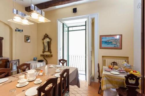 a dining room with a table with chairs and an open door at Bed and Breakfast Adelberga in Salerno