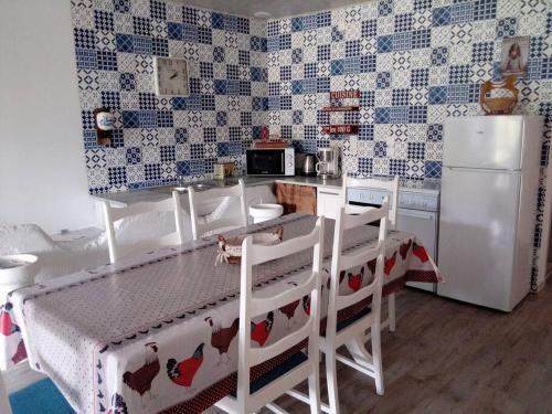 Il comprend une cuisine équipée d'un réfrigérateur, d'une table et de chaises. dans l'établissement L'Etablourotte, ancienne étable, à Herpelmont