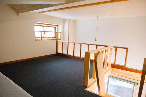 an empty room with a staircase and a window at Schanze Nozawa in Nozawa Onsen