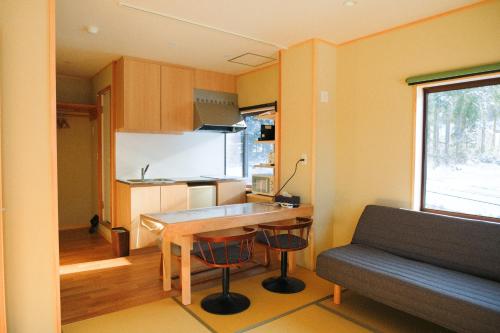 a small kitchen with a table and a couch at Schanze Nozawa in Nozawa Onsen