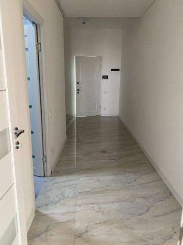 an empty hallway with white walls and wood floors at Two bedroom MEGA MALL Hills Sports & Spa adjacent120Meter13Ff in Yerevan
