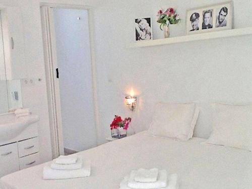 1 dormitorio blanco con 1 cama con 2 toallas en Appartement Chandon 4 pers, en Willemstad