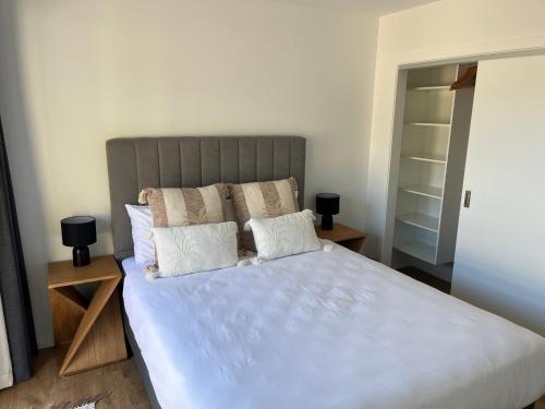 a bedroom with a large bed with white sheets and pillows at Studio in Glenorchy in Glenorchy
