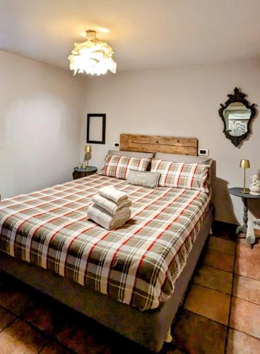 a bedroom with a large bed with a plaid blanket at La Ca' nel Borgo in Moltrasio