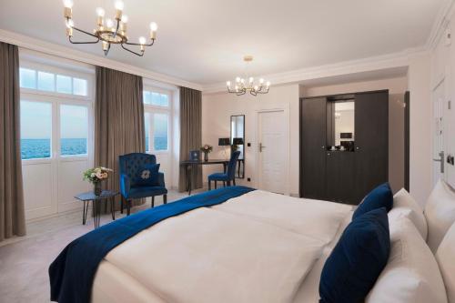 a bedroom with a large bed and a table and chairs at meergut HOTELS in Kühlungsborn
