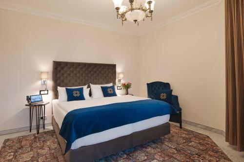 a bedroom with a large bed and a chandelier at meergut HOTELS in Kühlungsborn