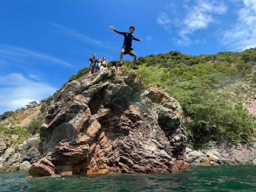 a man standing on top of a rock in the water at 湖上館パムコ in Wakasa