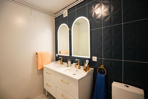 a bathroom with a sink and a mirror at T3 Premium Les Biches - Netflix Haut débit - 6 couchages - Parking gratuit in Font-Romeu
