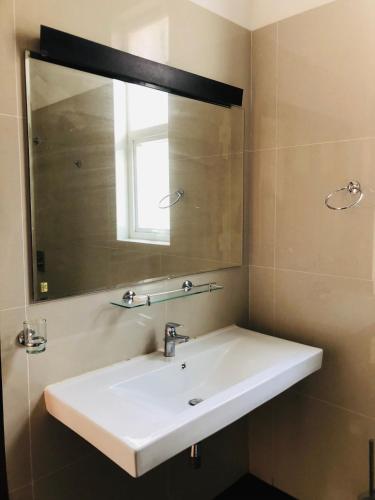 a bathroom with a white sink and a mirror at The Cloud Hanthana, Kandy in Kandy
