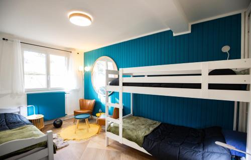 a bedroom with two bunk beds and a blue wall at T3 Premium Les Biches - Netflix Haut débit - 6 couchages - Parking gratuit in Font-Romeu