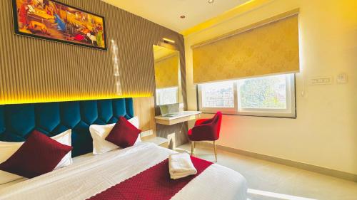アムリトサルにあるAmber B&B OPP GOLDEN TEMPLEのベッドと赤い椅子があるホテルの部屋