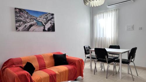 a living room with a couch and a table with chairs at Centrally Located Gzira in Il-Gżira