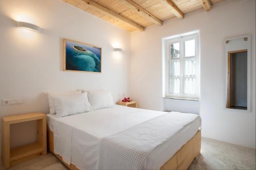 a bedroom with a large white bed in a room at K Homes-Family Stone Suite in Tinos Town