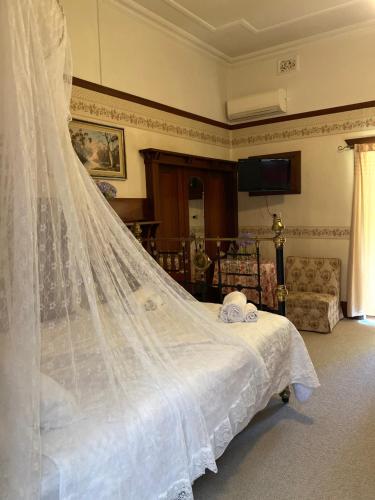 a wedding veil is hanging over a bed at Netherby Guesthouse in Kempsey