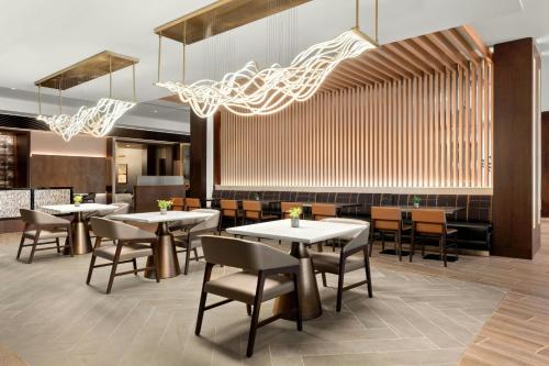 a restaurant with tables and chairs and a bar at Marriott San Antonio Airport in San Antonio