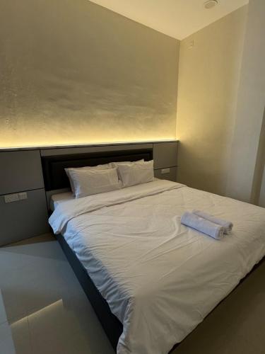 a large white bed with a blue towel on it at Monde Residence Block K number 17 in Bagam