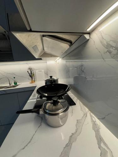 a kitchen with a stove with a pot on it at Monde Residence Block K number 17 in Bagam